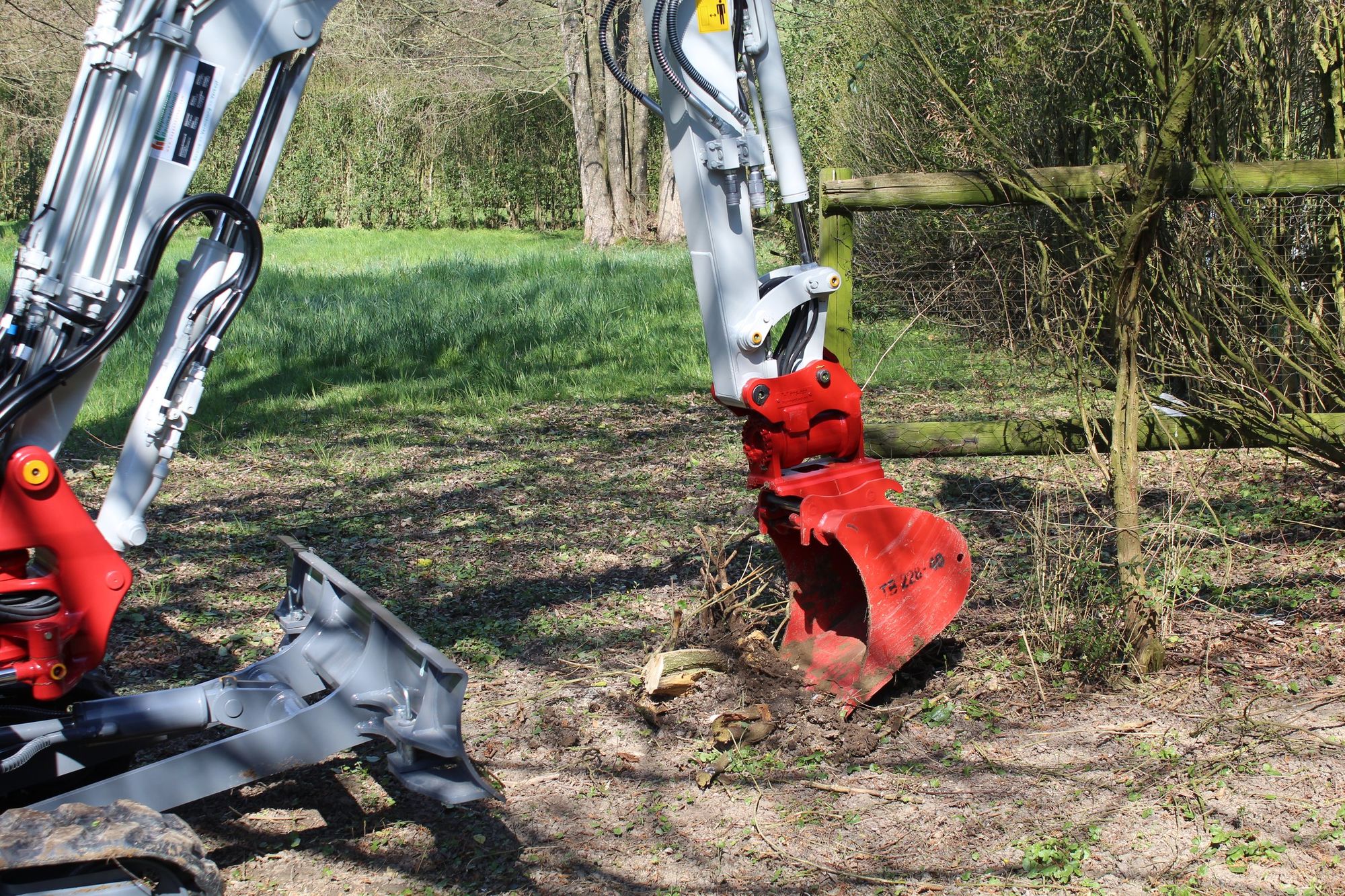Bagger mit Baumgreifer auf einer Wiese