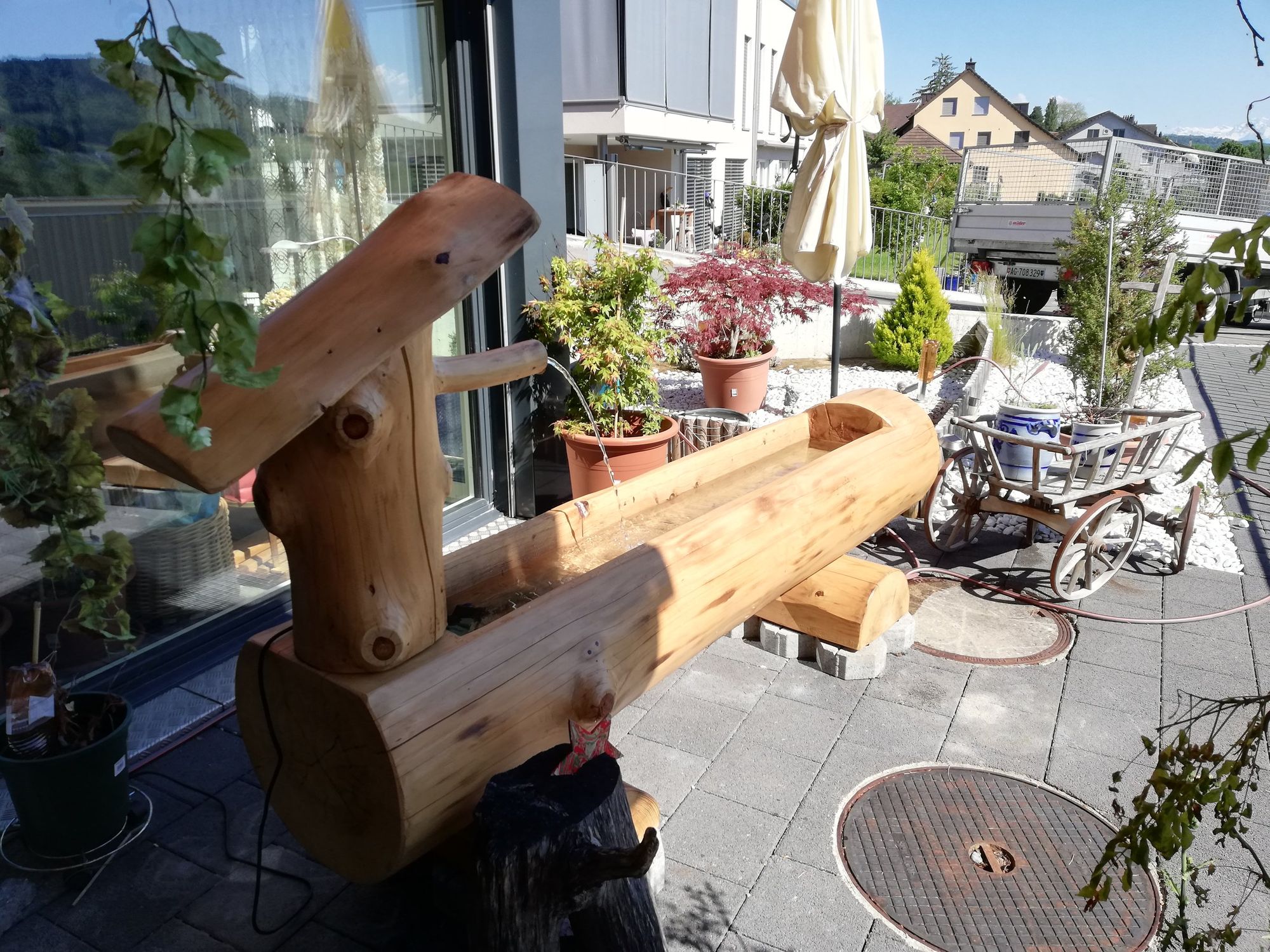 Brunnen aus Holzstämmen auf einer Terrasse