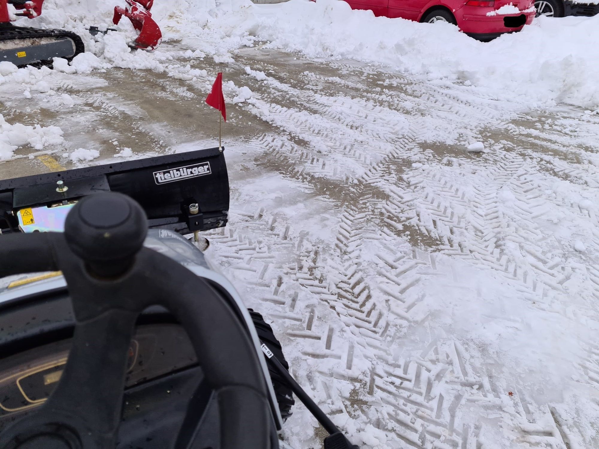Schneefräse im Einsatz auf einem verschneiten Platz
